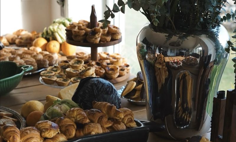 Mesa de festa da Girassol com pastéis de nata, croissants e fruta